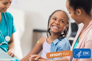 niña con profesional de atención médica y su madre riendo con el texto: #combatelainfluenza y el logo de los cdc
