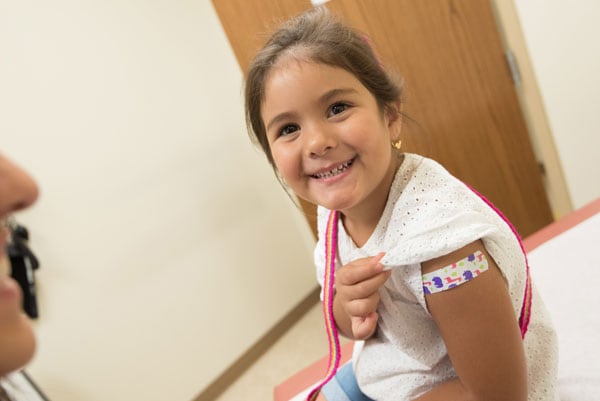 A smiling child who has just received a flu vaccine