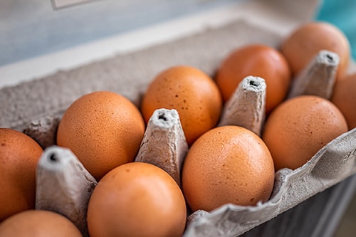 Brown chicken eggs in an egg carton.