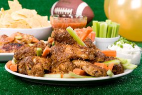 Chicken wings, chips, and other foods on a typical game day food tray.