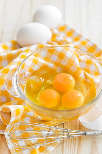 Egg yolks in bowl with whisk