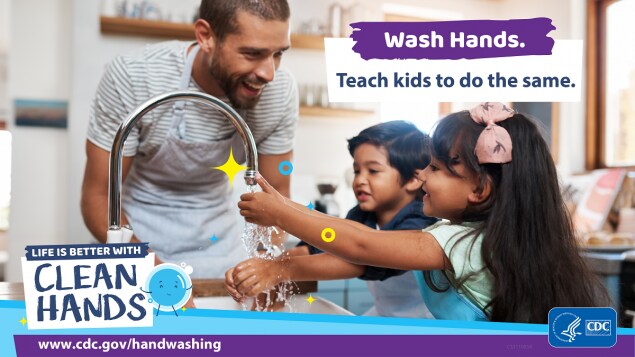 A man washing his hands with children in a kitchen and a reminder to teach kids to do the same.