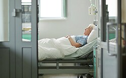 Anciana en la cama de un hospital de alto riesgo de intoxicación alimentaria