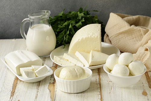 Various white cheeses in bowls and on dishes.