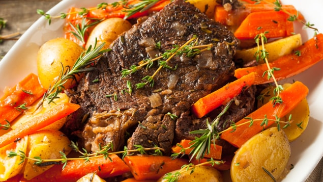 beef roast with potatoes and carrots on a platter