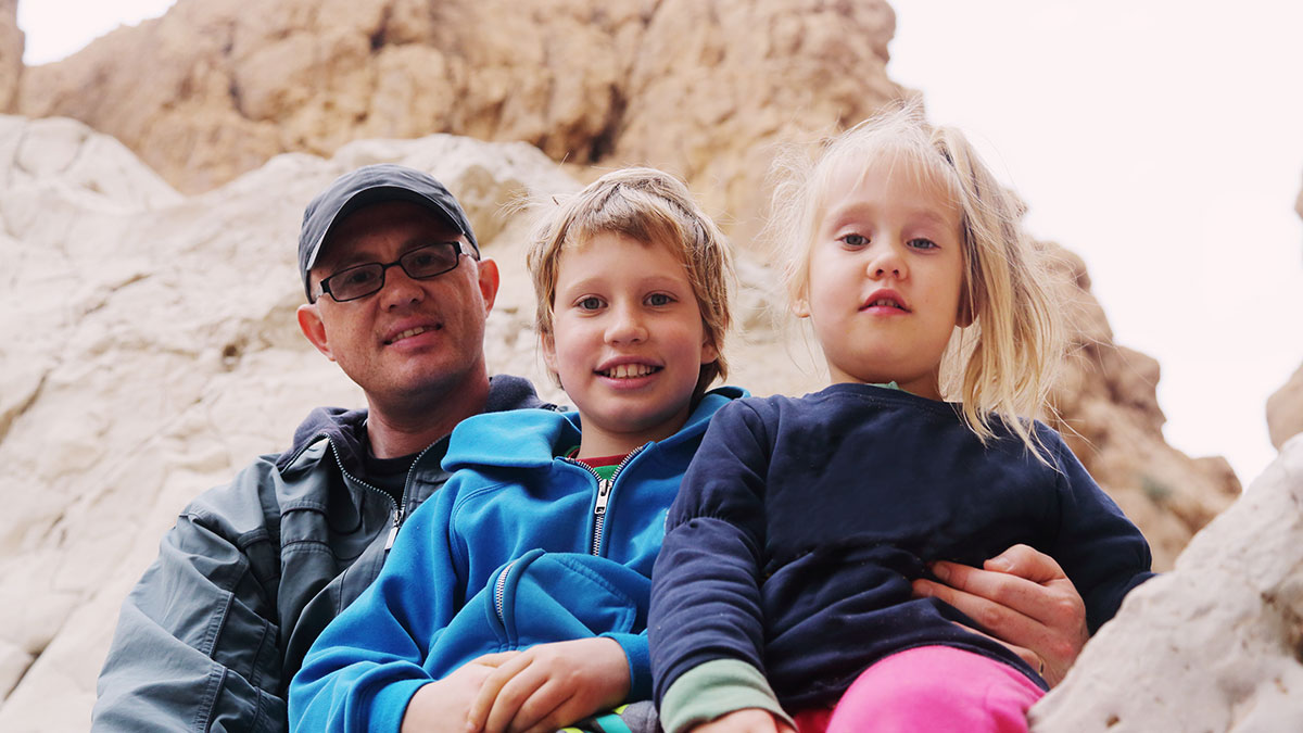 Father sitting with two children that have a disability