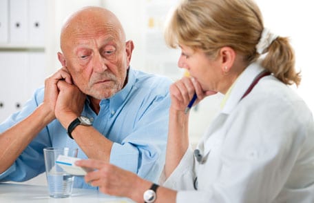 Imagen de un hombre mayor escuchando a una enfermera.