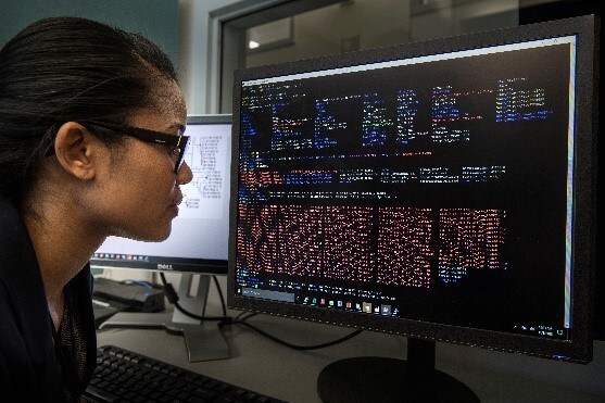 A woman analyzing whole genome sequencing data on a computer screen