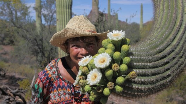 Photo of Sabine smiling next to cactus flowers