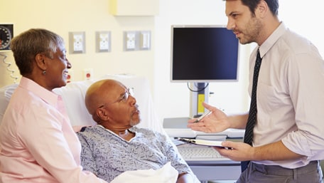 elderly couple talking to doctor in the hospital