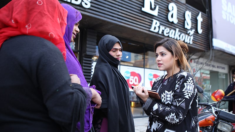 Photo of four women talking in front of a store.