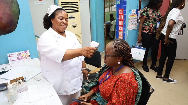 A nurse taking the temperature of a patient