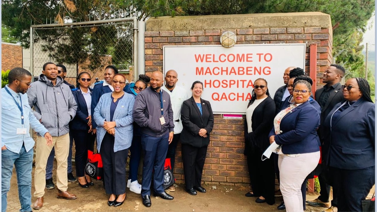 The picture features AMB Brewer (center, black suit and blue shirt), CDC staff, Motebang Hospital staff and Implementing Partner staff-- Elizabeth Glaser Pediatric AIDS Foundation (EGPAF).