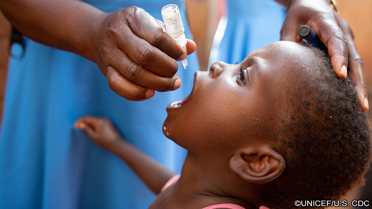 Photo of child receiving an oral vaccine in Malawi.