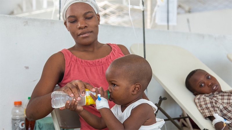 A young child receives oral rehydration therapy, a critical therapy, at a cholera treatment center in Haiti.
