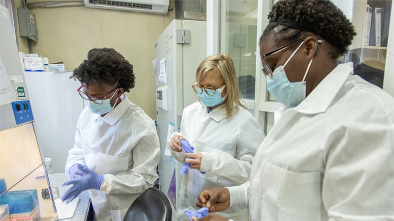 CDC microbiologist Maryann Turnsek (center) works with staff at the molecular biology department of the National Public Health Laboratory of Haiti to enhance the laboratory's ability to detect and respond to cholera cases.