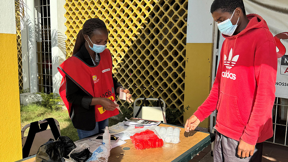 A young man checking-in with a “cough officer” at a health facility.