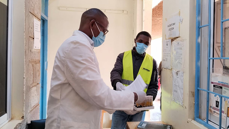 Hospital lab staff checks samples delivered by a rider in Kenya.