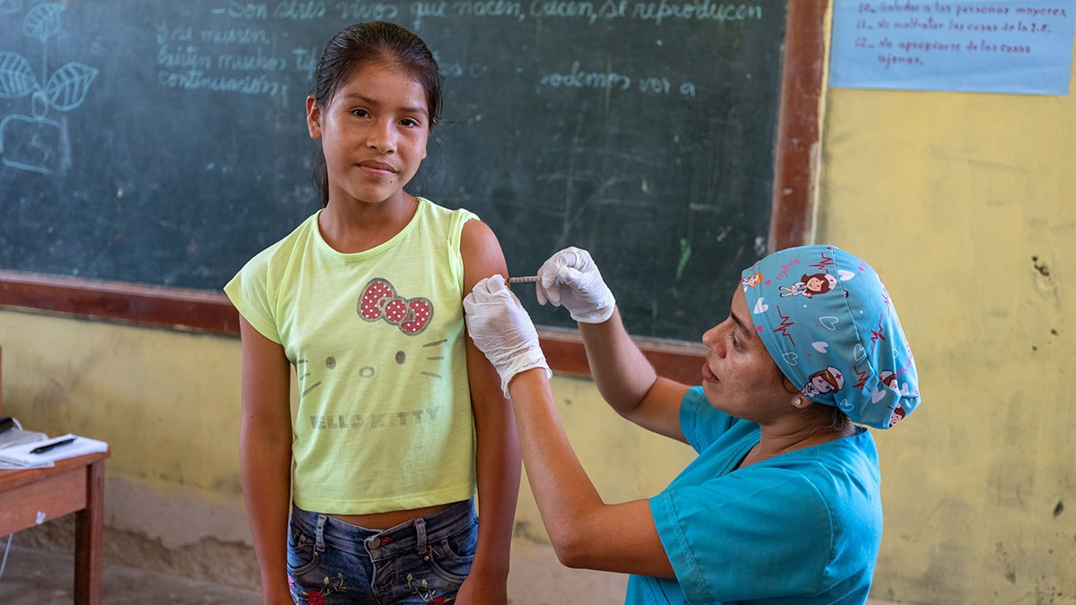 A healthcare worker vaccinating a girl.