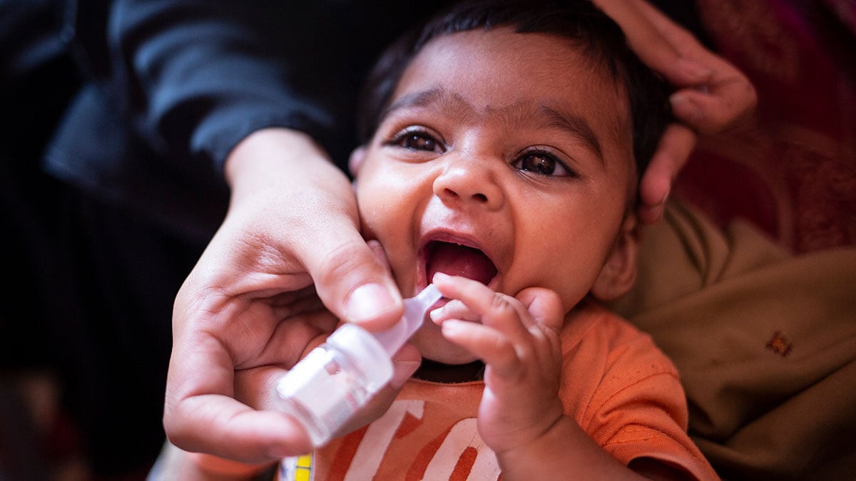 An infant is given oral polio vaccine.