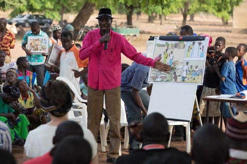 Presenters used flip-books to illustrate basic concepts about disease recognition to more than 400 residents from the small village of Dougoumato as part of Burkina Faso’s effort to broaden its ability to detect potential disease threats. (Source: Evelyn Hockstein, CDC Foundation)