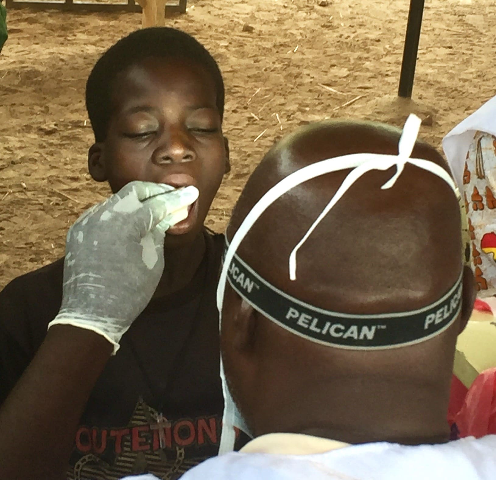 A technician swabs the cheek of a child as part of an effort supported by CDC to gauge the long-term impact of a new meningitis vaccine at a makeshift clinic in a remote village two hours from Burkina Faso’s capital. (Source: Charles Pope, CDC)