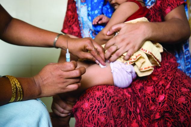 An infant is immunized against DPT at the Lotus Colony Health Post