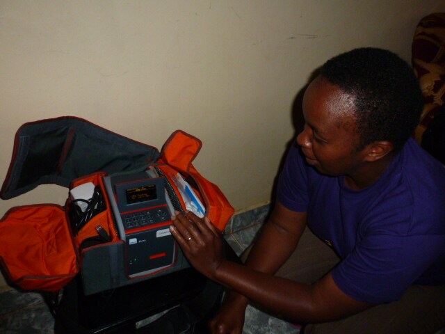 A lab technician performs quality control measures on the PIMA CD4 Analyser before going out for data and specimen collection.