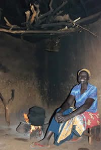Women traditionally use a 3-stone stove indoors for cooking in Kenya