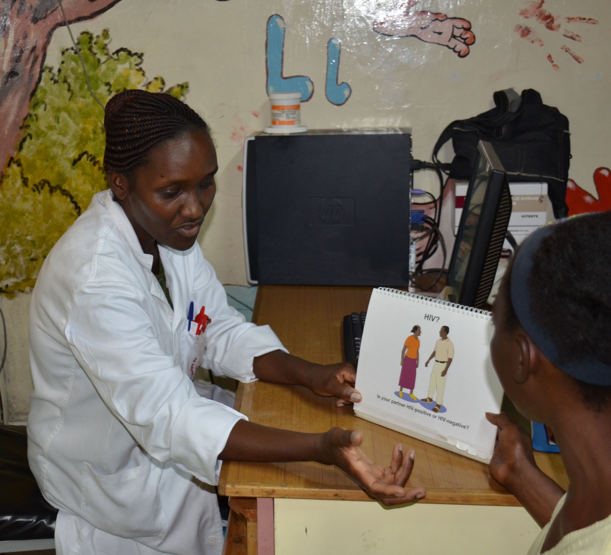 Jelius Muraguri, PMTCT nurse at EDARP, discusses HIV prevention and care with one of the mothers attending CDC- supported Komarock Clinic