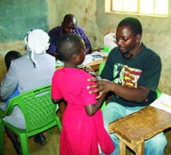 CDC staff David Ousu (clinician) and Dr. Joash Gombe (pediatrician) assisting with a free medical camp held in Uluthe, Ugunja District in November 2009