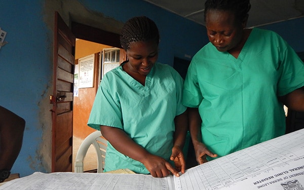 Community health workers review reports from a health facility in Kambia district.