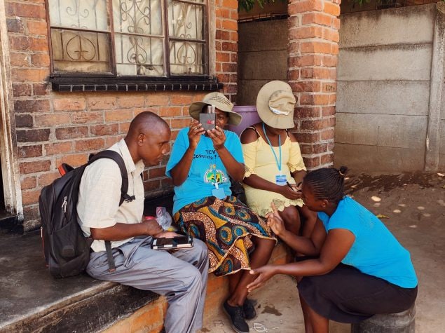 Data collectors interviewing a household and testing water sample for chlorine level for the TCV coverage survey (April 2019)