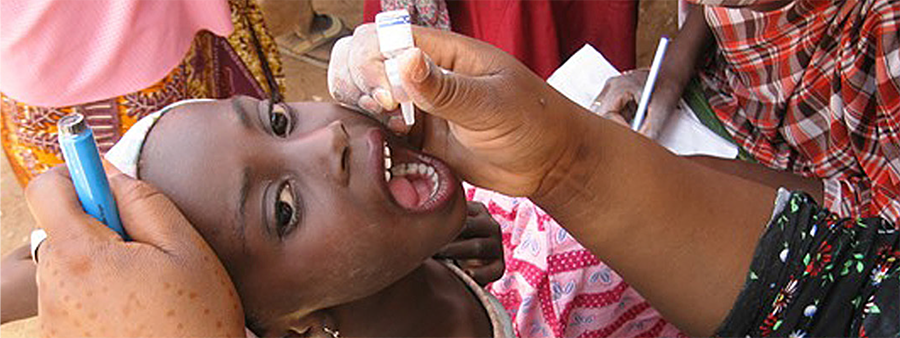 girl receiving oral polio drops