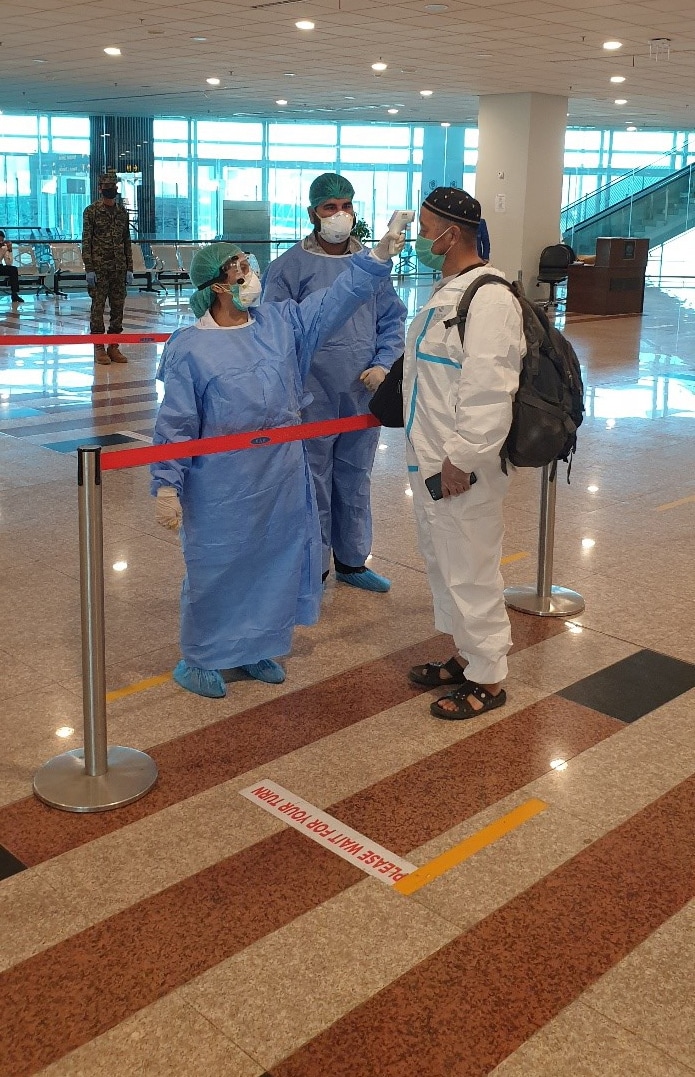 FELTP graduate Dr. Nadia Noreen screens a traveler for COVID-19 symptoms at Islamabad Airport in Pakistan.