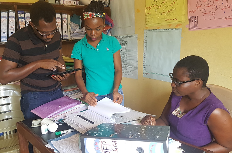 Team members review records as part of a health evaluation in Nigeria. Photo: Tamuno-Wari Numbere