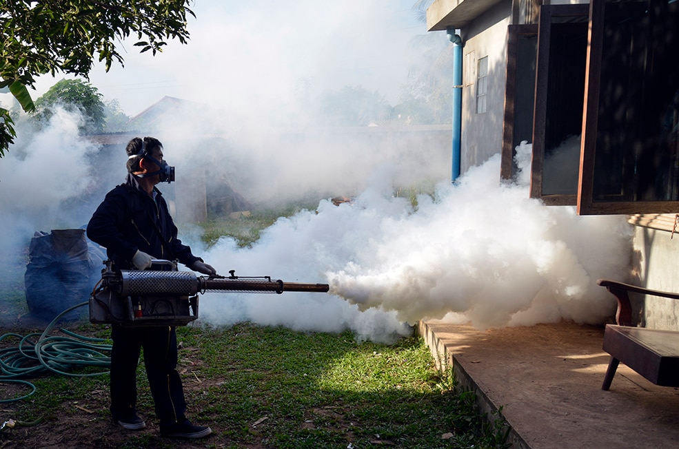 Lao FETP trainee spraying pesticides to control insects. Photo: Billy Weeks