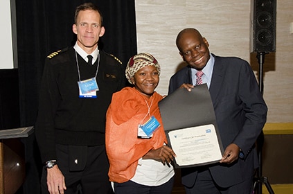 South Africa FELTP resident Mrs. Itumeleng Moema (center), winner of the 2018 Jeffrey P. Koplan Award for Excellence in Scientific Presentation accepting the award from Dr. Kip Baggett (left) and Dr. Dionisio Herrera Guibert (right) in recognition of her outstanding poster presentation titled Outbreak of Culture-confirmed Candida auris Bloodstream Infection in the Neonatal Unit of a Public-sector Hospital, South Africa, July through September 2017.