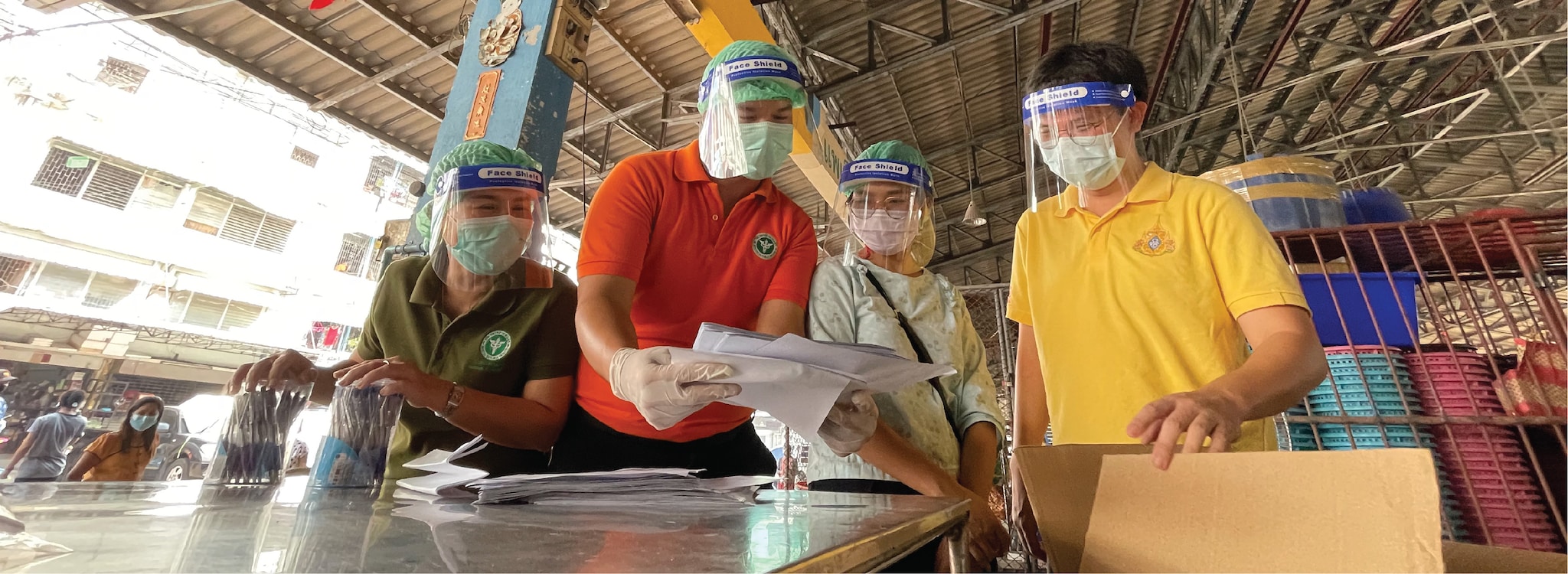 Dr. Ern and other Thai investigators prepare a questionnaire for Myanmar migrants at the shrimp market.