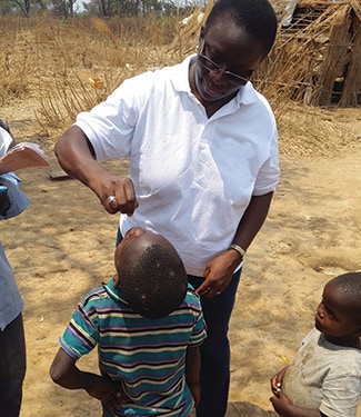 Dr. Aissata Daiha from CDC's Global Immunization Division administering the oral polio vaccine in a remote area of Lumbumbashi. Photo: Louie Rosencrans, CDC.
