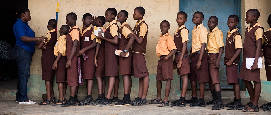 Students from Atu Government School in Calabar, Nigeria, receive medicines for NTDs during a mass drug administration. Photo: Ruth McDowall, RTI International.