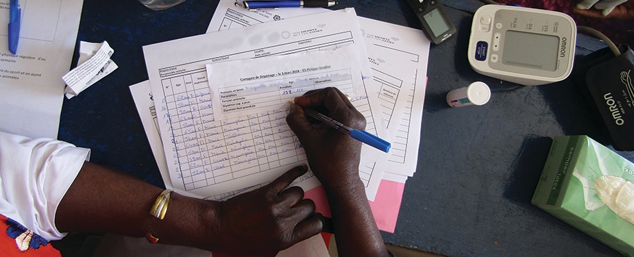 A health worker completes patient paperwork at a clinic. Photo: Cheick Niang.