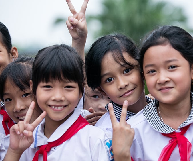 A group of school kids in Vietnam smile and pose for the camera. Photo: RTI International