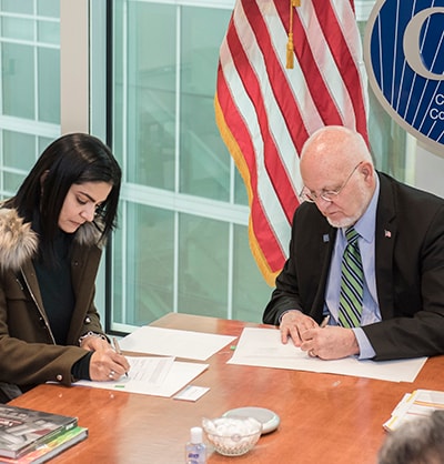 CDC Director Robert Redfield signing a Memorandum of Agreement with Colombia INS Director Martha Ospina, February 2019. Photo: Lauren Bishop