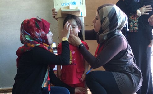 Survey team members measuring the height of a Syrian girl in Za'atari camp to assess her nutritional status (Source: Eva Leidman, CDC)