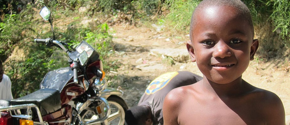 A boy by a road in Haiti, where geographic information systems save lives and money for healthcare facilities. Photo: CDC