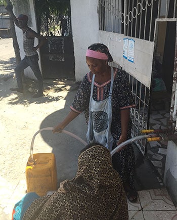 Filling water jugs to take home. Photo: Anu Rajasingham, CDC