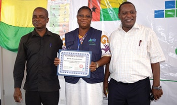 Placido Carsado (right), Director of the National Institute of Health, and Serifo Monteiro, Director of the National Public Health Laboratory, flanking Sabado Fernandes, an FETP-Frontline graduate in Guinea-Bissau. Photo: Ken Johnson.