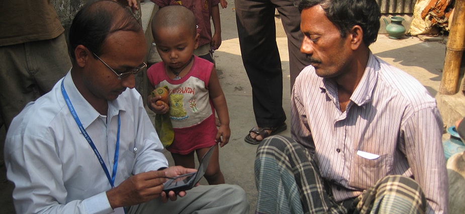 A field epidemiologist interviews a man in a Bangladeshi village. Field epidemiologists collect and analyze health data as well as assist during emergencies.