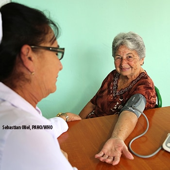 Nurse takes older woman's blood pressure in a clinic.